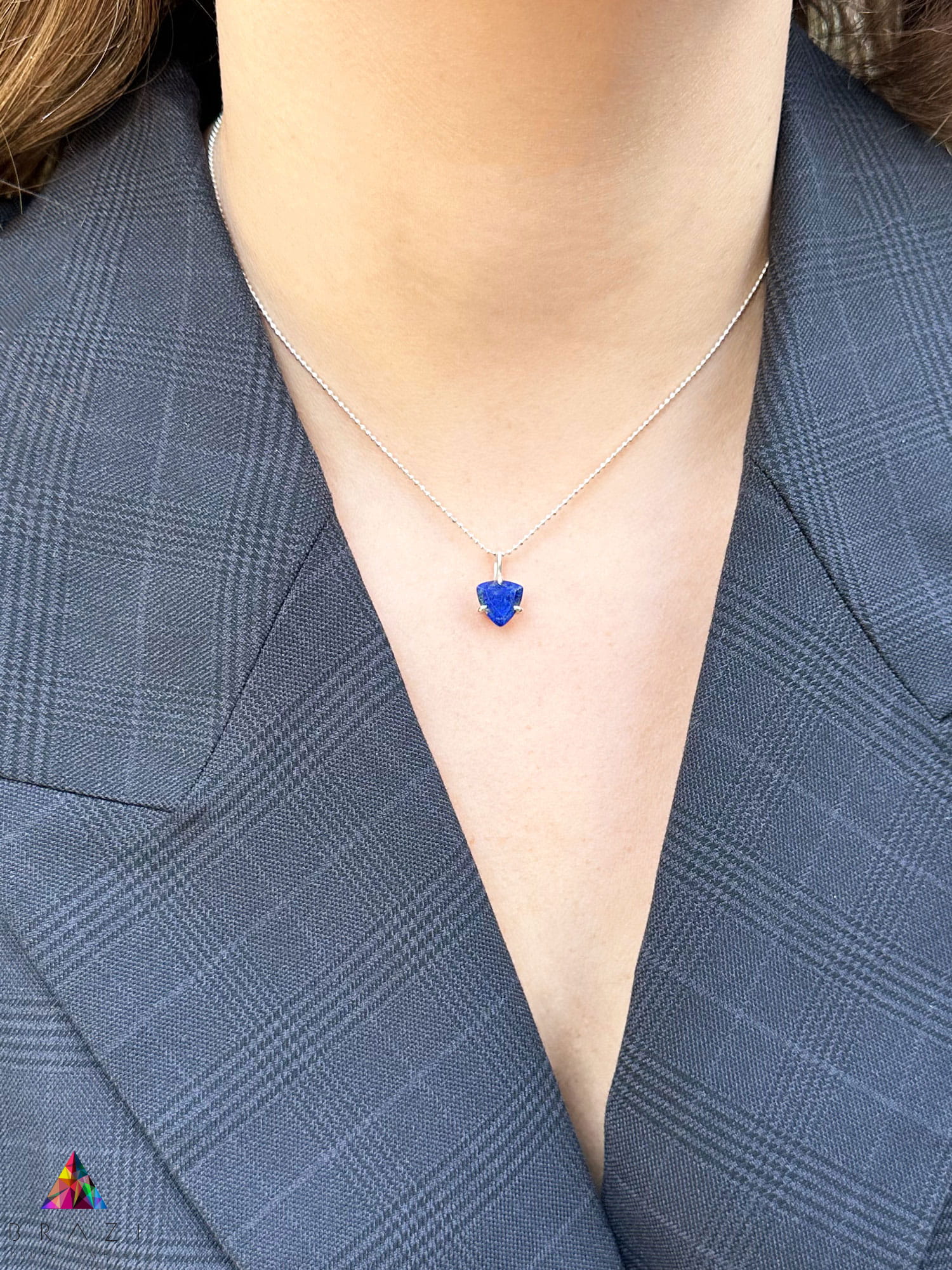 Naszyjnik z naturalnym lapis lazuli o szlifie trylion w srebrnej oprawie, biżuteria Brazi na modelce.