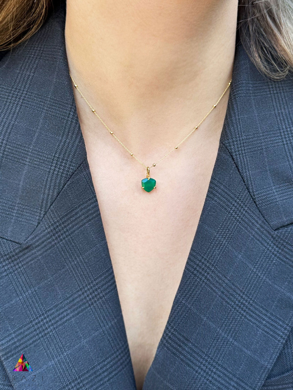 Naszyjnik z zielonym chalcedonem w oprawie z żółtego złota na szyi modelki, biżuteria marki Brazi