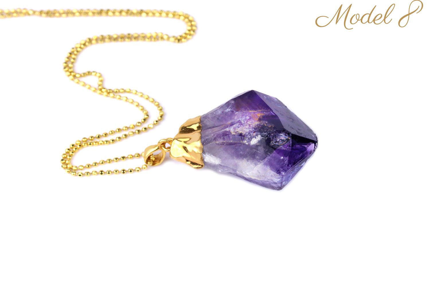 Naszyjnik z dużym, ciemnym ametystem o surowych krawędziach, złocona oprawa, biżuteria marki Brazi.