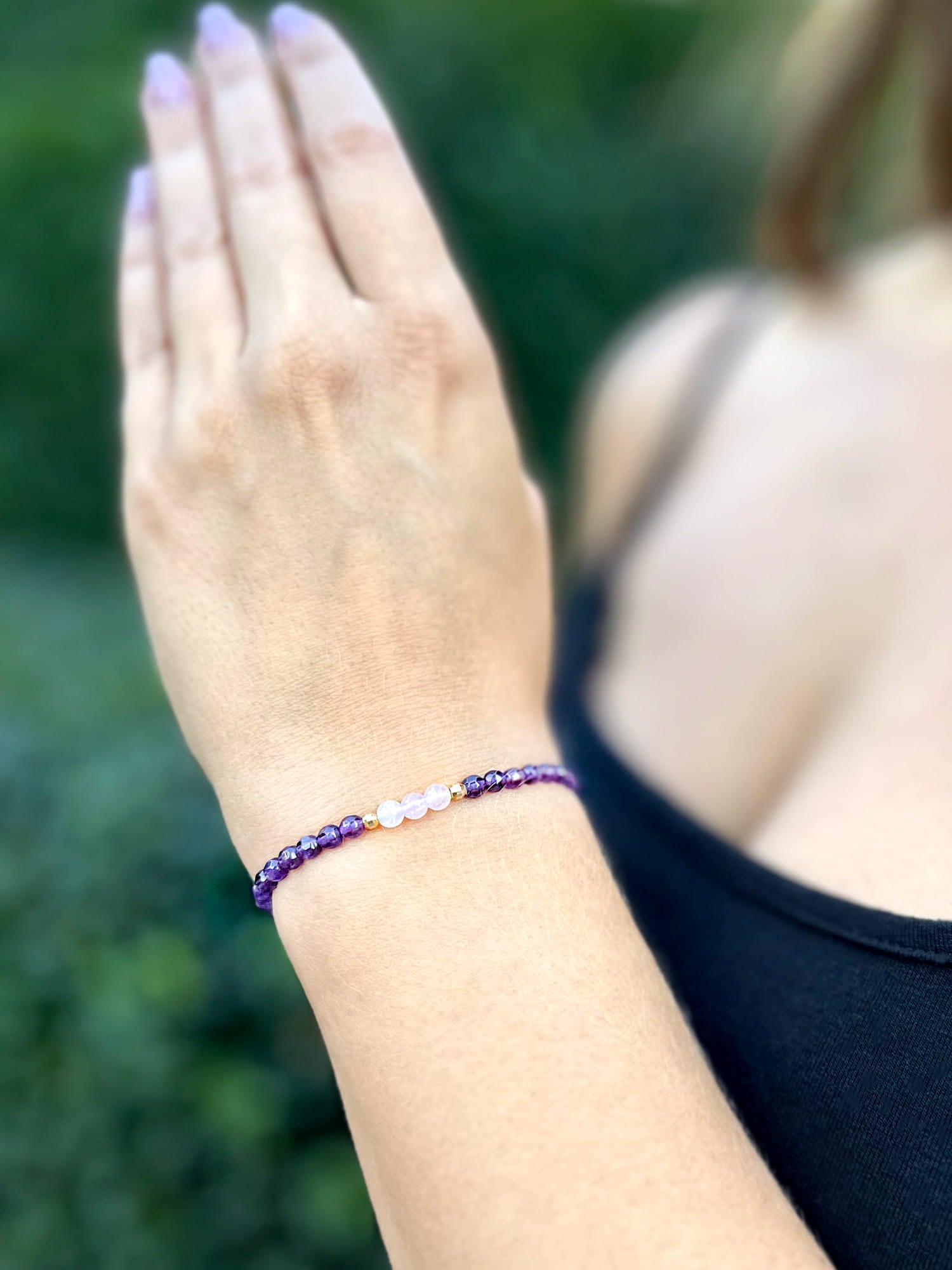 Bransoletka z ametystu i kwarcu różowego na nadgarstku modelki, gładkie kuliste minerały, biżuteria Brazi