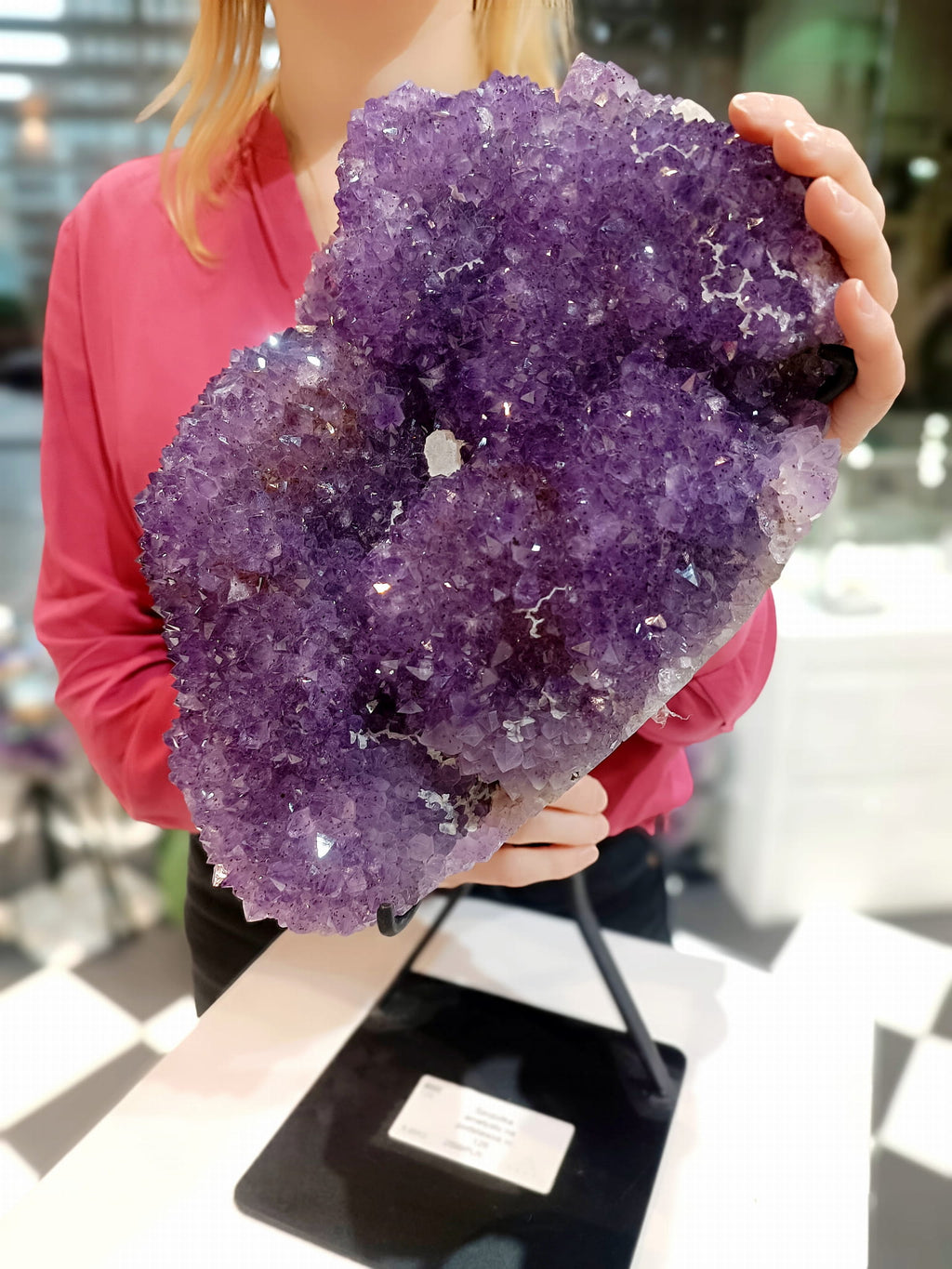 Szczotka naturalnego ametystu o głębokim fioletowym kolorze trzymana w dłoniach, minerał od Brazi.