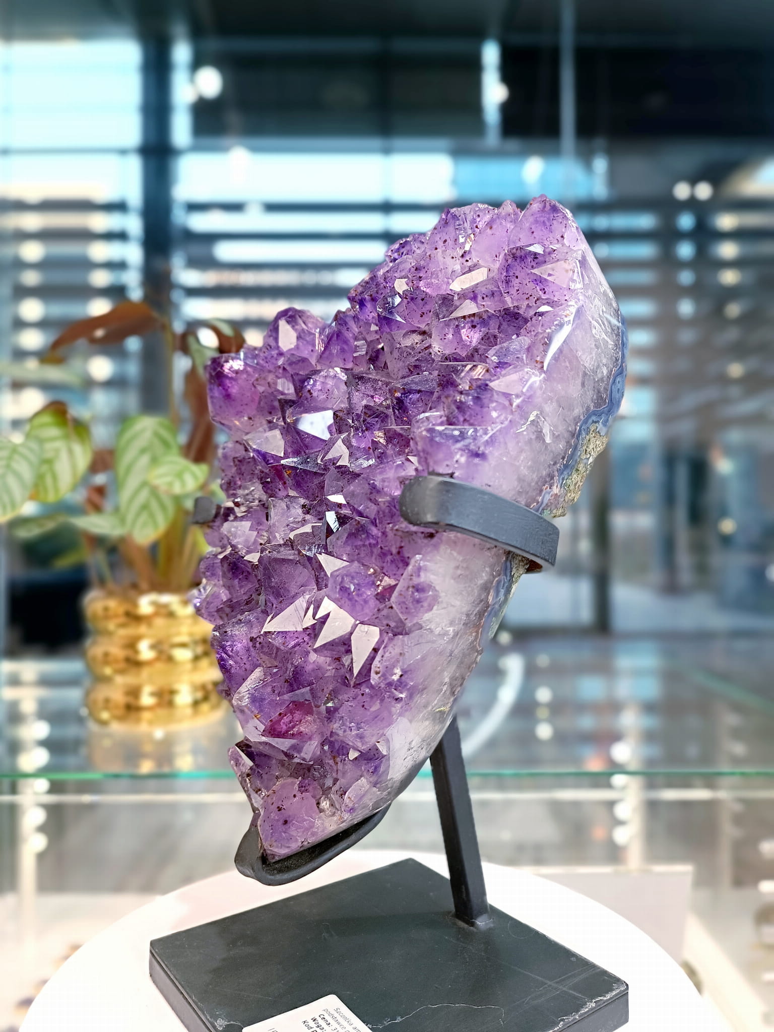 Szczotka ametystu na metalowej podstawce, widok z profilu ukazujący surową strukturę skały, Brazi Druse Jewelry.