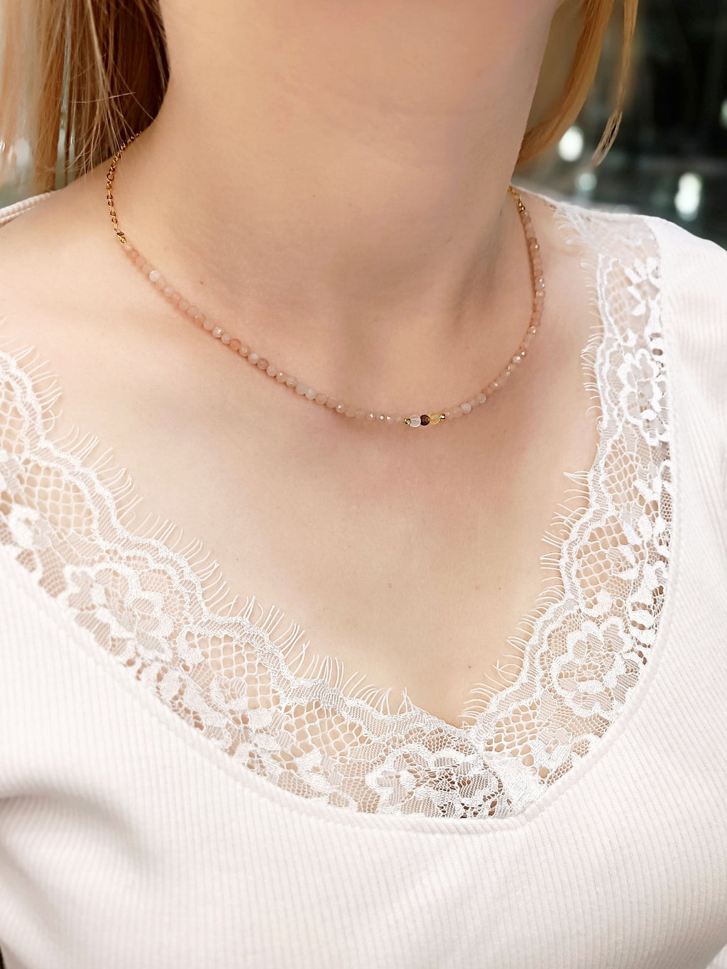 Złocony naszyjnik z różowymi kamieniami na dekolcie modelki, biżuteria handmade Brazi