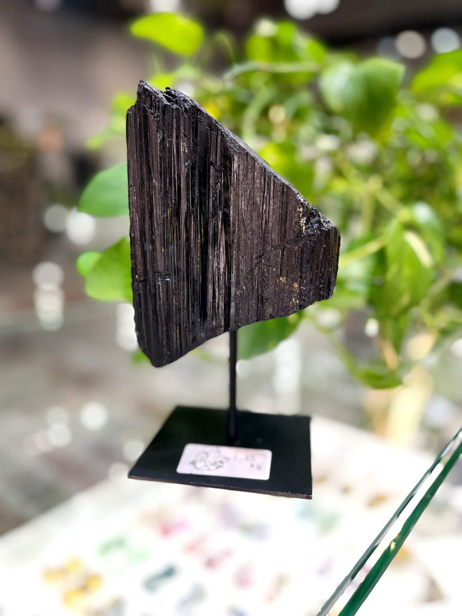 Czarny turmalin o prążkowanej strukturze na metalowej podstawce, naturalny minerał od Brazi