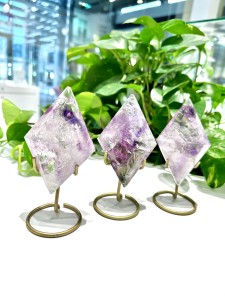 Elegancki ametystowy diament osadzony na lśniącej złotej podstawce, doskonały prezent dla miłośników luksusowej biżuterii. Idealnie komponuje się z nowoczesnymi i klasycznymi stylizacjami.