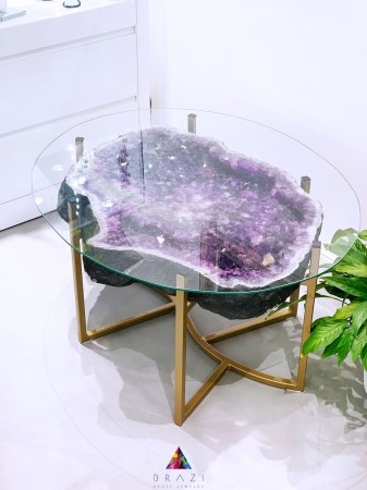 Stolik kawowy z wyjątkowym blatem z plastra geody ametystu, ważący 73 kg. Elegancki design i naturalne piękno kryształu idealnie dopełnią wystrój każdego wnętrza, tworząc unikalny punkt centralny w salonie.