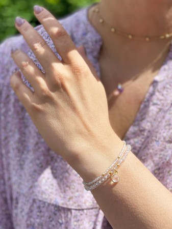 Elegancka podwójna bransoletka z kryształem górskim i subtelną zawieszką, doskonała na każdą okazję. Ręcznie wykonana z dbałością o detale, idealna dla miłośników unikalnej biżuterii.