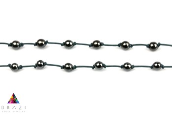 Męski naszyjnik z hematytu na ciemnym sznurku, zbliżenie na splot i regularne odstępy koralików, Brazi