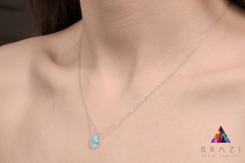 Naszyjnik ze srebrnym łańcuszkiem i naturalnym topazem na dekolcie modelki, biżuteria Brazi