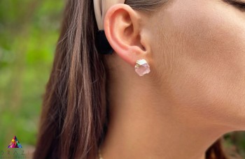 Kolczyki z surowym kwarcem różowym i subtelnym złoceniem na uchu modelki, marka Brazi.