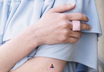 Pierścionek z kwarcem różowym w srebrnej oprawie, ujęcie z boku na dłoni, biżuteria Brazi