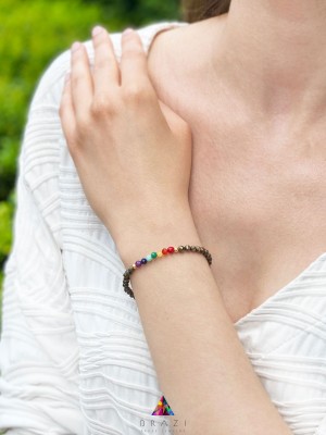 Bransoletka z pirytu i wielobarwnych kamieni naturalnych na nadgarstku modelki, biżuteria Brazi.