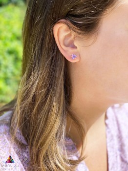 Kolczyki z naturalnym ametystem w oprawie ze złota próby 585 na uchu modelki, biżuteria Brazi.