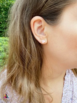 Złoty kolczyk z naturalnym kwarcem różowym o szlifie trylion na uchu modelki, biżuteria Brazi