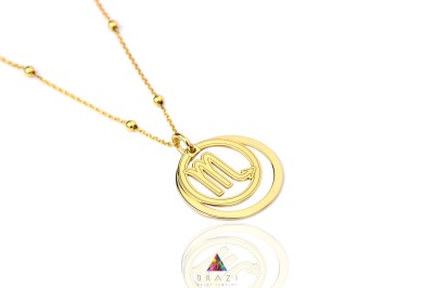 Naszyjnik w kolorze złotym z podwójną zawieszką z symbolem Skorpiona i ozdobnym łańcuszkiem, biżuteria Brazi.