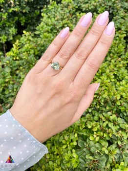 Pierścionek z naturalnym prasiolitem o szlifie trylion w oprawie ze złota 585 na dłoni modelki, biżuteria Brazi.