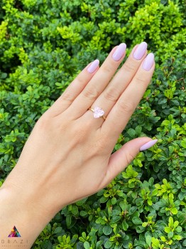 Złoty pierścionek z naturalnym kwarcem różowym 4 ct na dłoni, biżuteria Brazi w świetle dziennym.