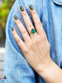 Złoty pierścionek z błękitnym chalcedonem w szlifie kropli na dłoni modelki, marka Brazi