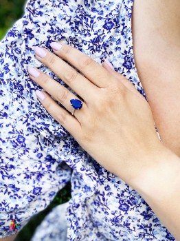 Srebrny pierścionek z lapis lazuli w szlifie kropli, dłoń na tle biało-niebieskiej sukienki, Brazi.