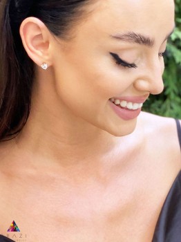 Kolczyki z naturalnym kryształem górskim w złotej oprawie na uchu modelki, biżuteria Brazi.