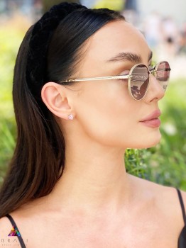 Kolczyki z kwarcem różowym o szlifie trylion na uchu modelki, biżuteria marki Brazi