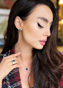 Zestaw biżuterii z topazem London Blue w złotej oprawie na modelce w marynarce, marka Brazi.