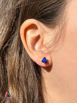 Kolczyki z naturalnym lapis lazuli o szlifie trylion w srebrnej oprawie na uchu modelki, biżuteria Brazi.