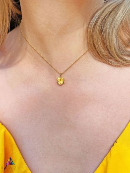 Złoty naszyjnik z cytrynem 4 ct o szlifie trylion na tle żółtej tkaniny, biżuteria Brazi