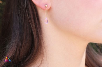 Złote kolczyki z kwarcem różowym na uchu modelki, wiszące krople z naturalnego kamienia Brazi