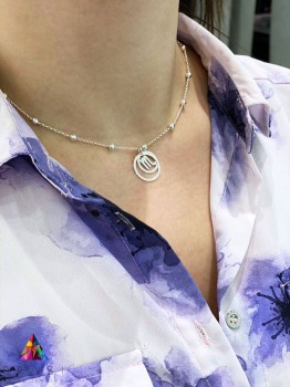 Srebrny naszyjnik z zawieszką przedstawiającą symbol Skorpiona na dekolcie modelki, biżuteria Brazi.