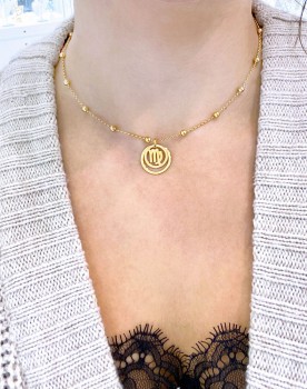 Złoty naszyjnik z okrągłą przywieszką o gładkim wykończeniu prezentowany na modelce, biżuteria Brazi