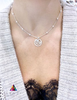 Srebrny naszyjnik z okrągłym medalionem o polerowanej strukturze na szyi modelki, biżuteria Brazi