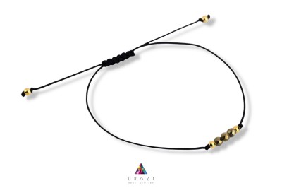 Bransoletka Szczęścia Brazi Druse Jewelry z pirotem, złota oprawa, na czarnym sznurku.