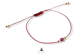 Bransoletka z naturalnym rubinem na czerwonym sznurku ze złotymi kuleczkami, ręcznie wykonana biżuteria Brazi.