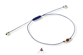Bransoletka sznurkowa z naturalnym granatem i złotymi kuleczkami na białym tle, biżuteria Brazi