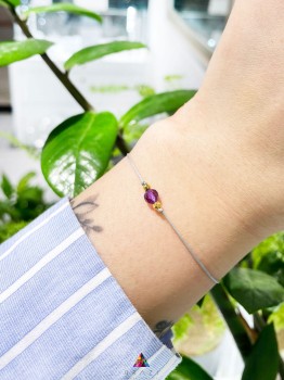 Delikatna bransoletka z ametystem, szara nić, złote akcenty.