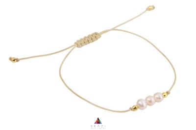 Bransoletka z trzema naturalnymi perłami na beżowym sznurku ze złotymi dodatkami, biżuteria Brazi.