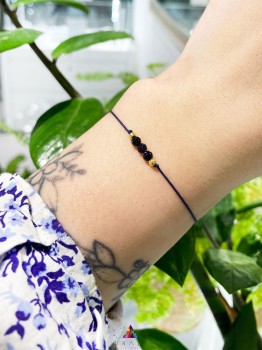 Bransoletka Noc Kairu na czarnym sznurku prezentowana na nadgarstku, biżuteria marki Brazi.