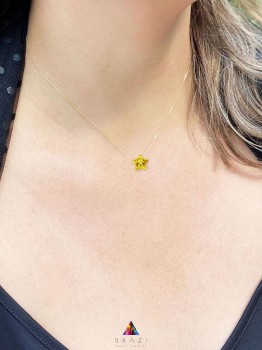 Naszyjnik z cytrynową gwiazdką na złotym łańcuszku prezentowany na szyi modelki, marka Brazi