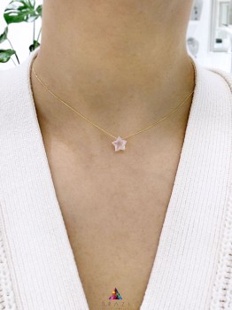 Naszyjnik z kwarcem różowym w kształcie gwiazdki i złotym łańcuszkiem, biżuteria Brazi na szyi modelki