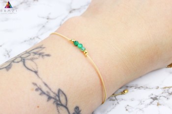 Bransoletka z naturalnym malachitem na beżowym sznurku ze złotymi przekładkami, biżuteria Brazi