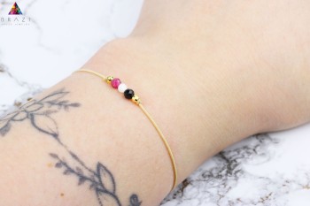Bransoletka z różowym, białym i czarnym kamieniem naturalnym na nadgarstku, marka Brazi