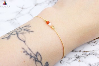 Bransoletka z fasetowanych kamieni naturalnych i złotych przekładek na beżowym sznurku, biżuteria Brazi