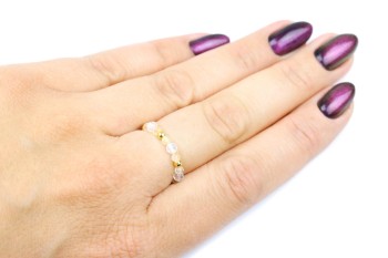 Złoty pierścionek z fasetowanym kryształem górskim i cytrynem na dłoni, marka Brazi