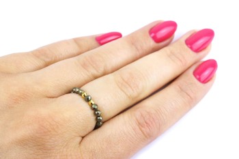 Szeroki pierścionek z fasetowanego pirytu ze złotymi elementami na dłoni, biżuteria marki Brazi