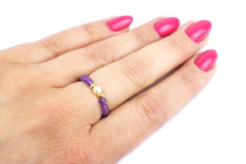 Elastyczny pierścionek z fioletowym ametystem i perłą na palcu dłoni, biżuteria marki Brazi