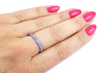 Pierścionek z naturalnym tanzanitem i złotymi elementami na dłoni, biżuteria Brazi.