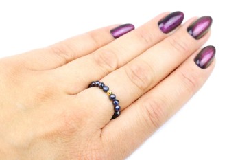 Pierścionek z fasetowanych szafirów i złota na dłoni modelki, biżuteria marki Brazi