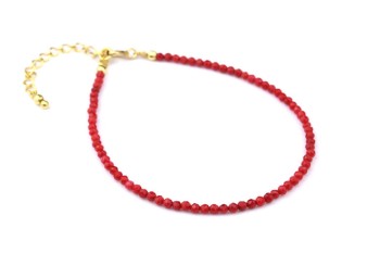 Bransoletka z fasetowanym koralem i złotym zapięciem na białym tle, biżuteria Brazi