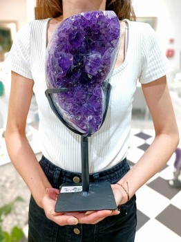 Prezentacja skali dużej szczotki ametystu na podstawce trzymanej przez osobę, biżuteria Brazi.